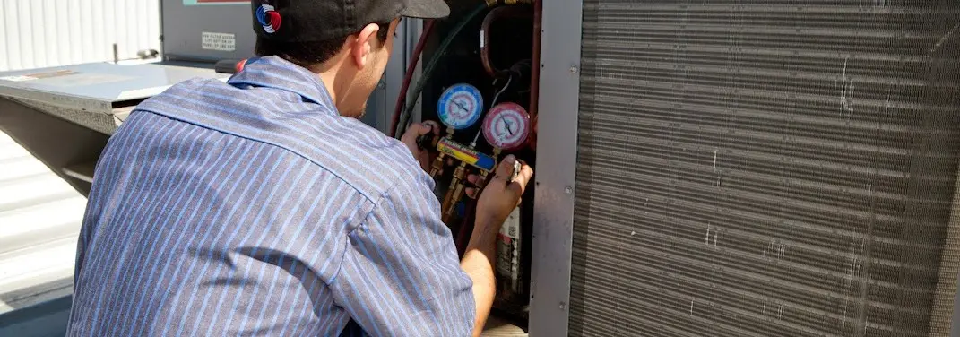 HVAC technician servicing a condenser unit in North Lauderdale